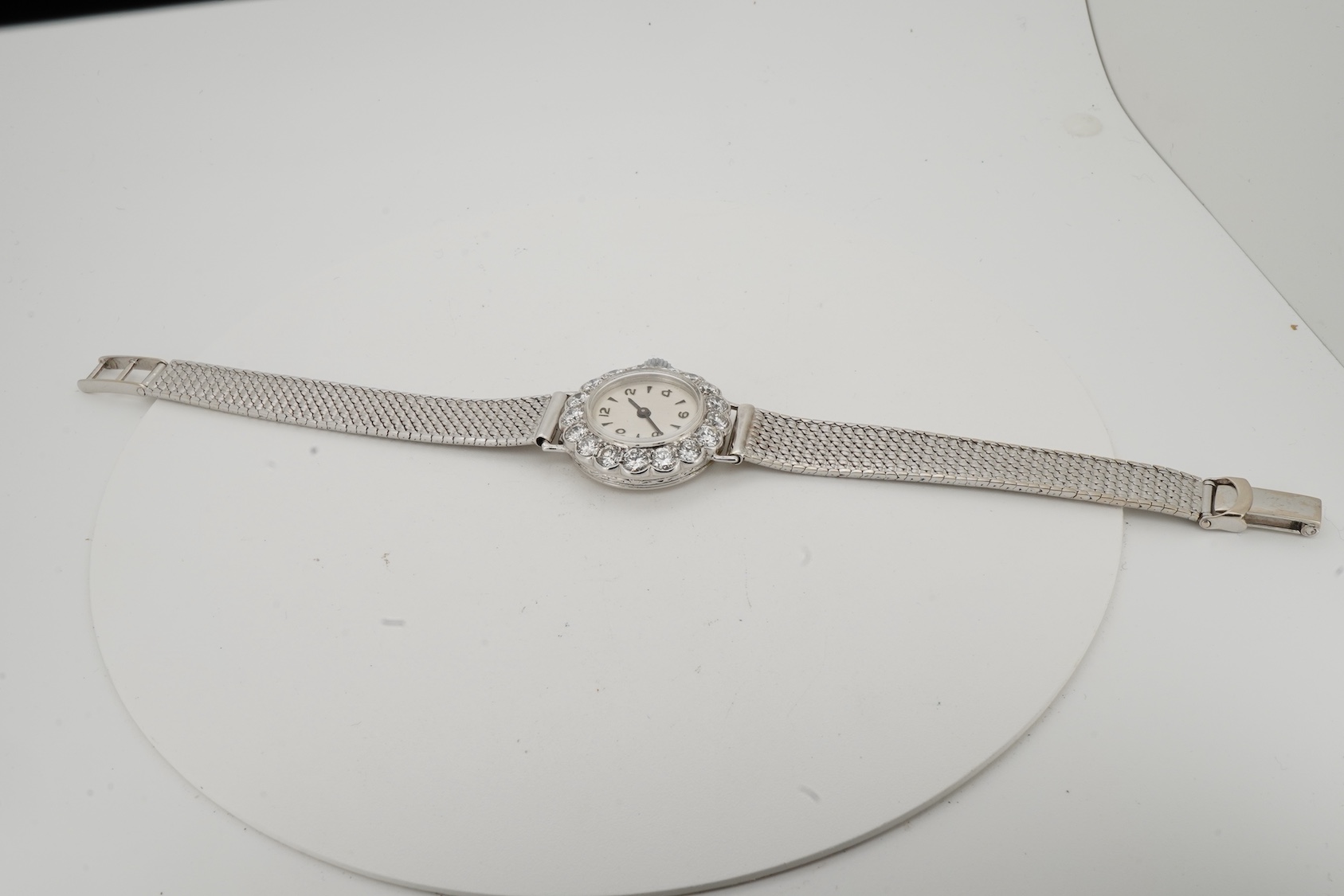 A lady's early 1940's platinum and diamond set manual wind cocktail watch, on a 9ct white gold mesh link bracelet